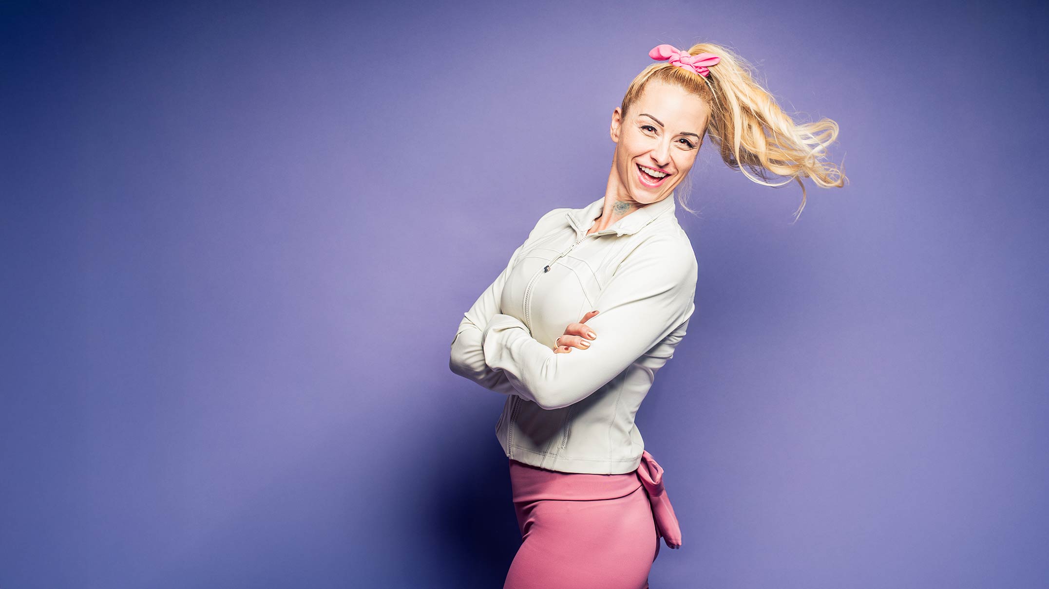 Jaime Leona smiling in athletic wear against a purple background